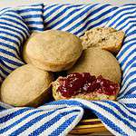 graham (whole wheat) gems in a basket; one with jam